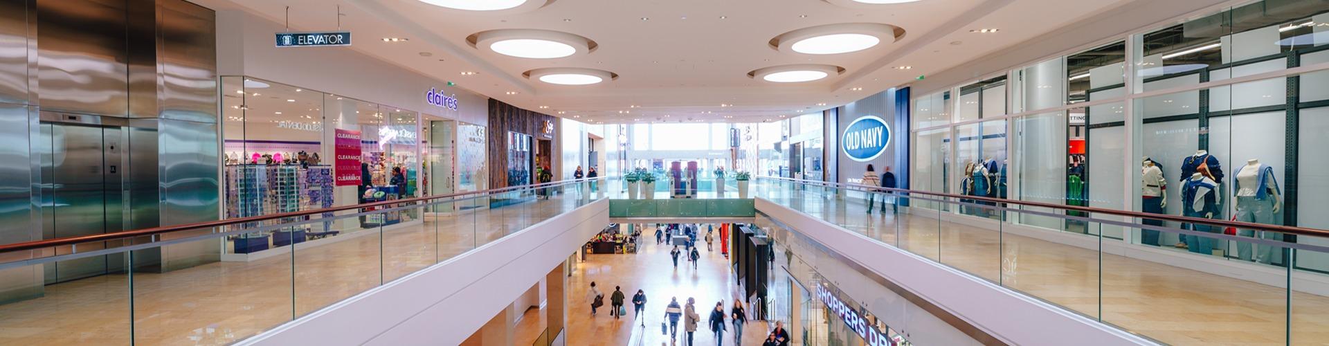 Two-level mall interior with Claire's and Old Navy and round ceiling lights