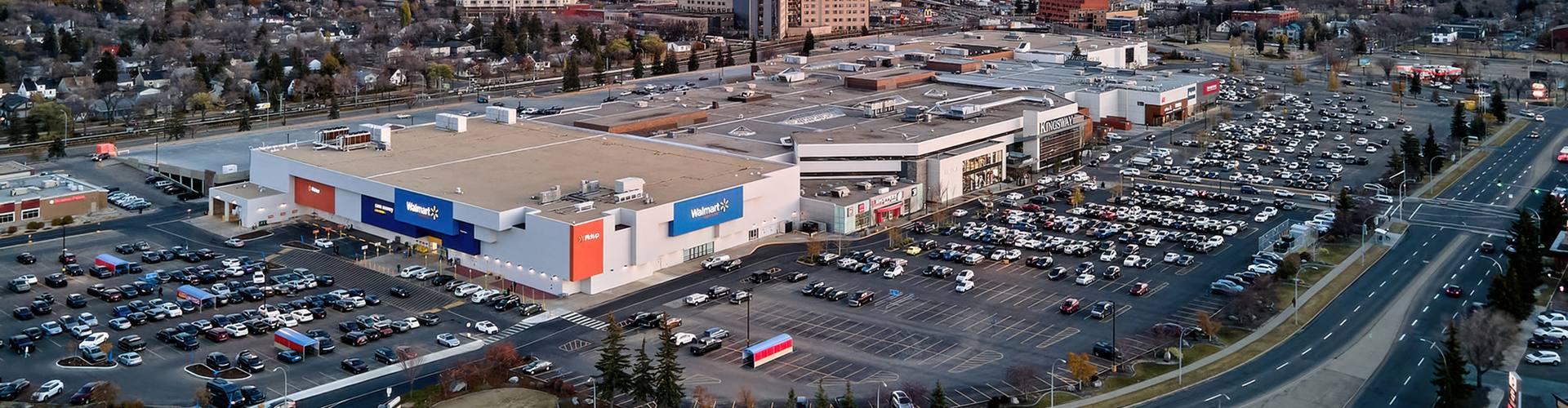 Aerial view of a Walmart-anchored mall and parking lots at dusk