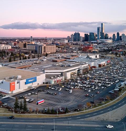 Aerial view of a Walmart-anchored mall and parking lots at dusk