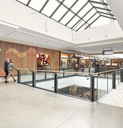 Upper-level mall walkway with lululemon and Roots storefronts