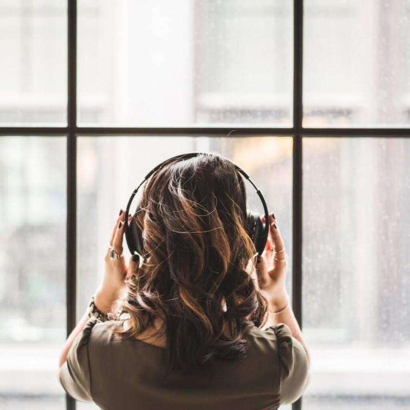 Woman listening to song through headphones