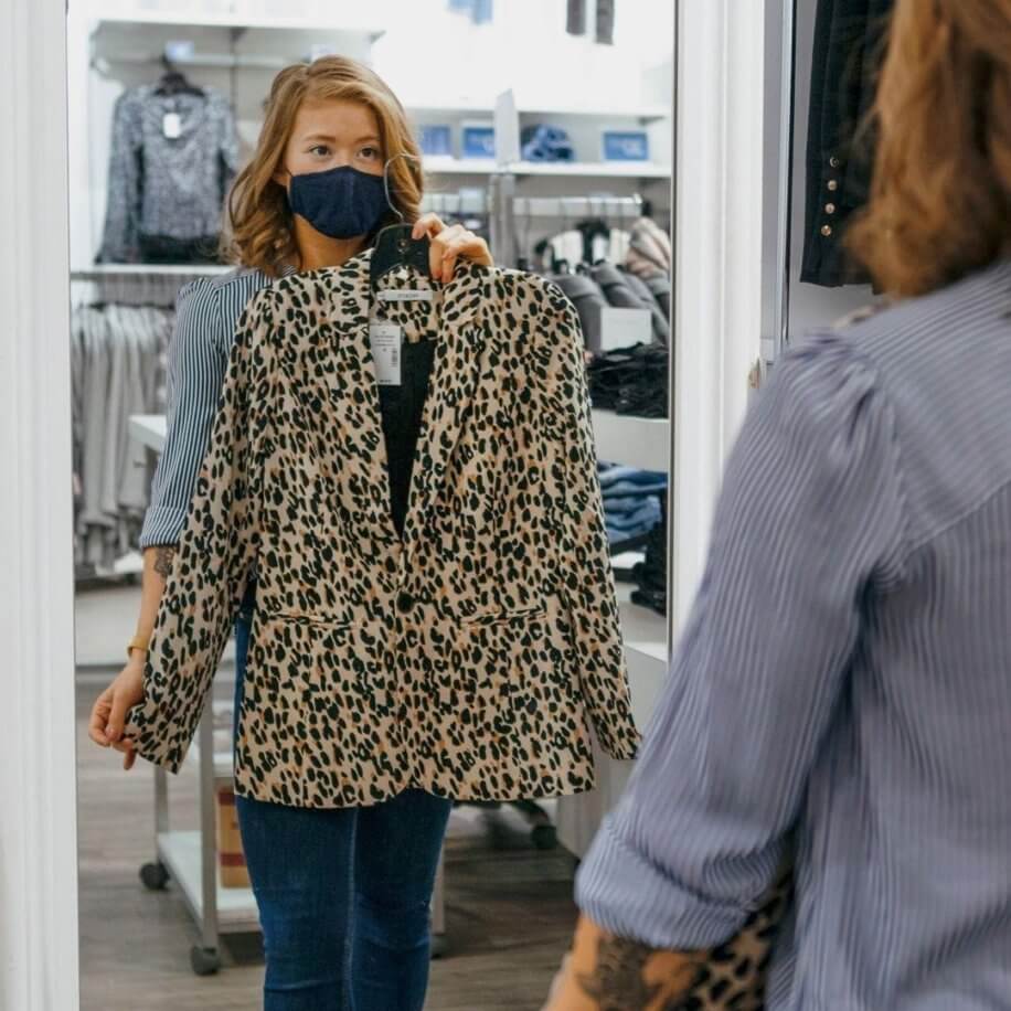 Woman holding up Cheetah print jacket