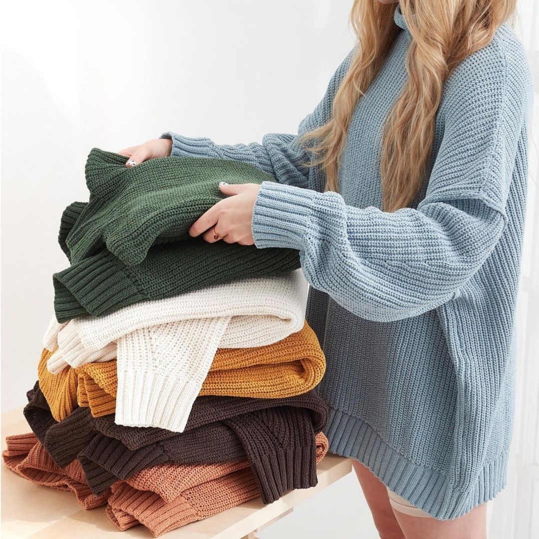 Woman folding knit sweaters