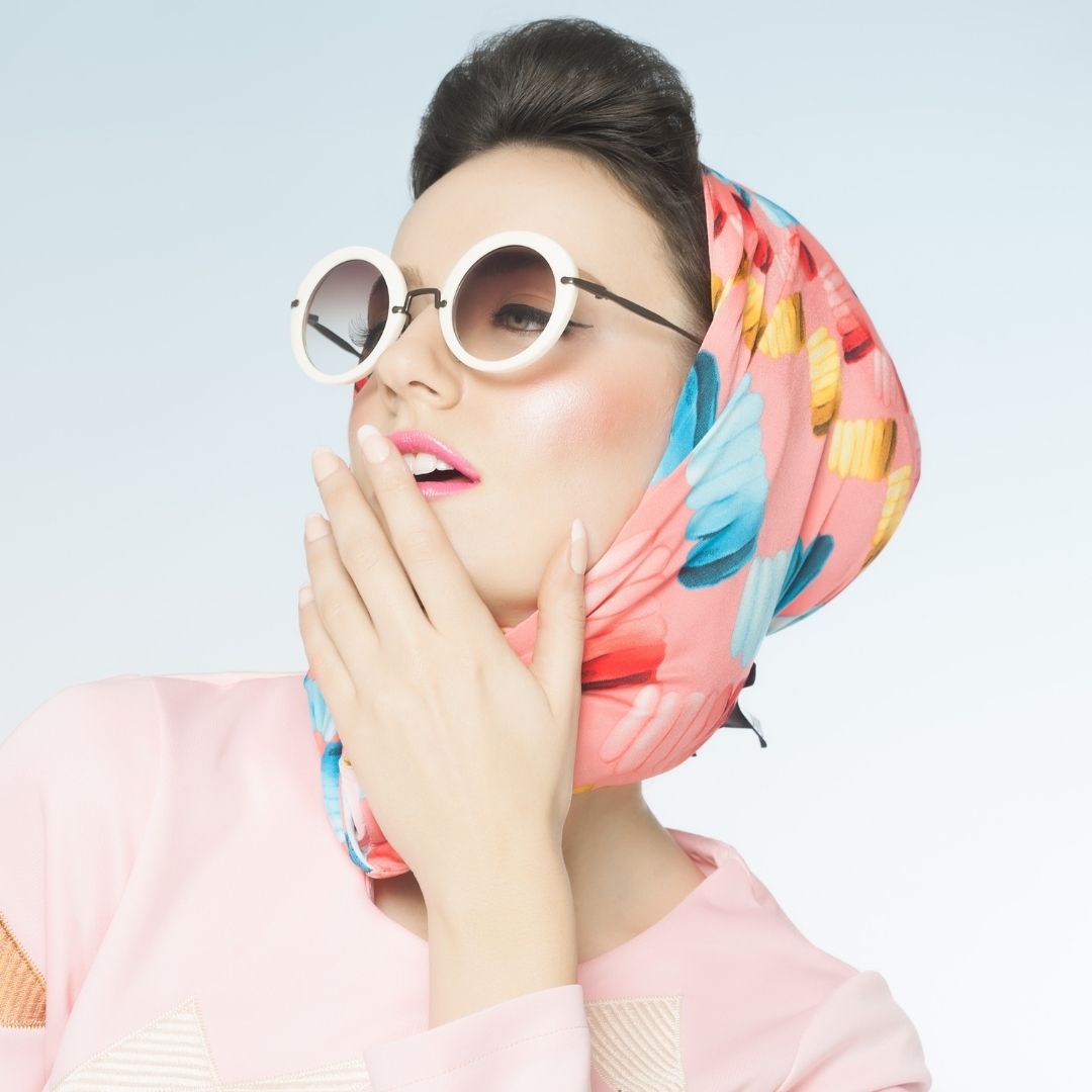Woman in a silk scarf and round glasses