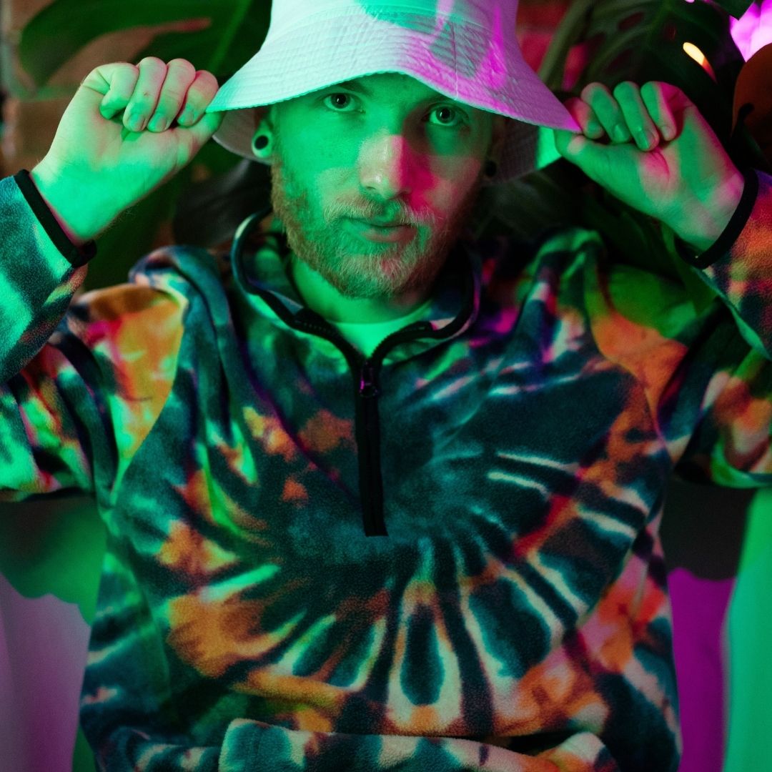 Man in a tie dye hoodie and white hat
