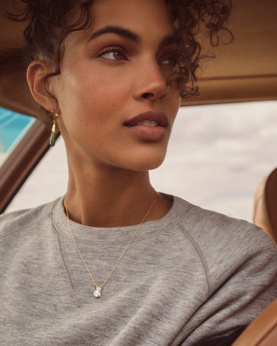 Woman wearing a grey shirt and a necklace