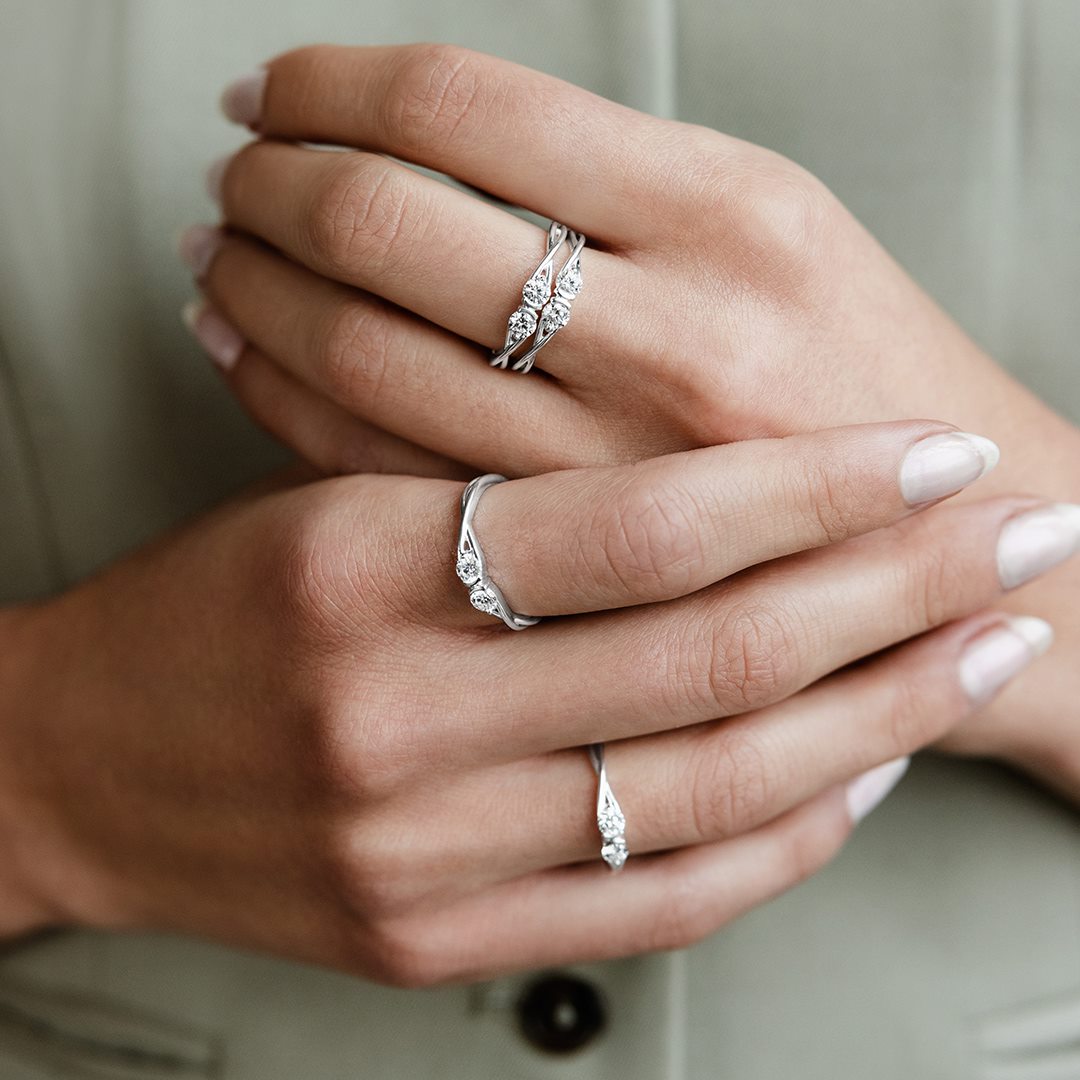 Stacks of silver rings on a models hand