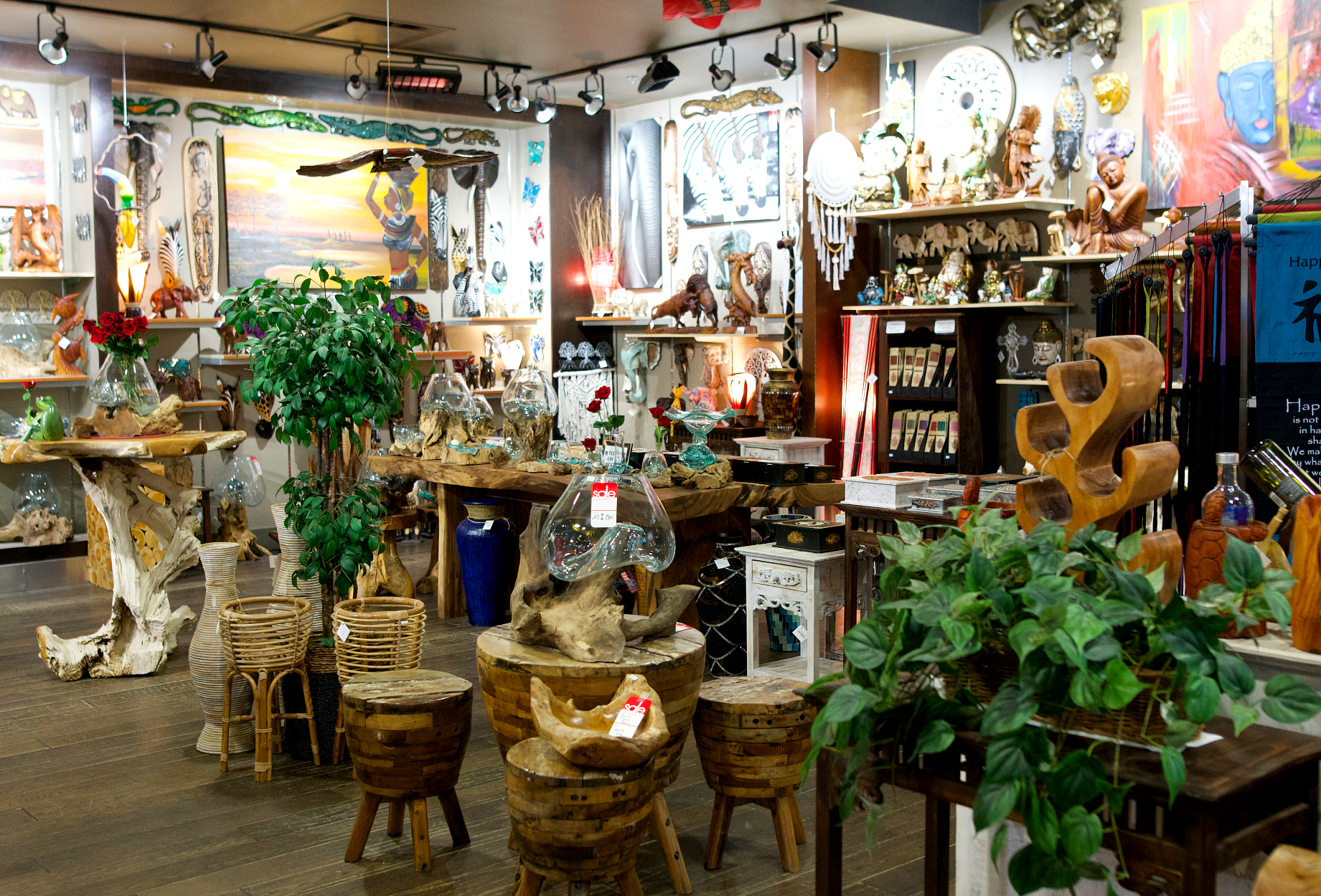 store interior with hand carved, wooden ornaments and stools with potted plants