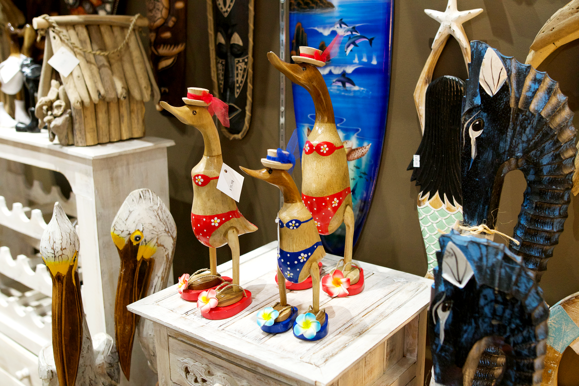 wooden duck statues wearing swimsuits and hats