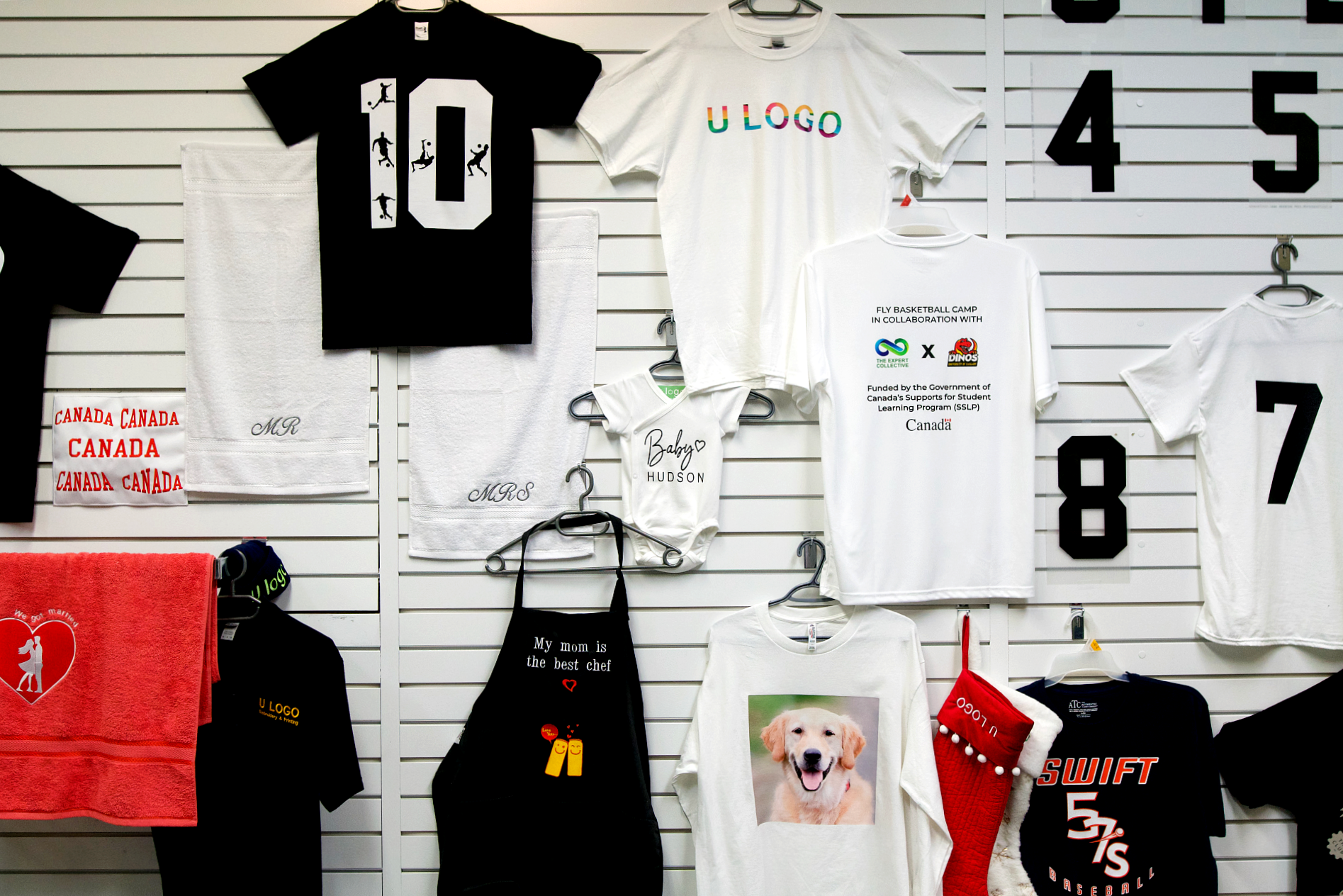 wall display of handmade graphic t-shirts and aprons at an embroidery store