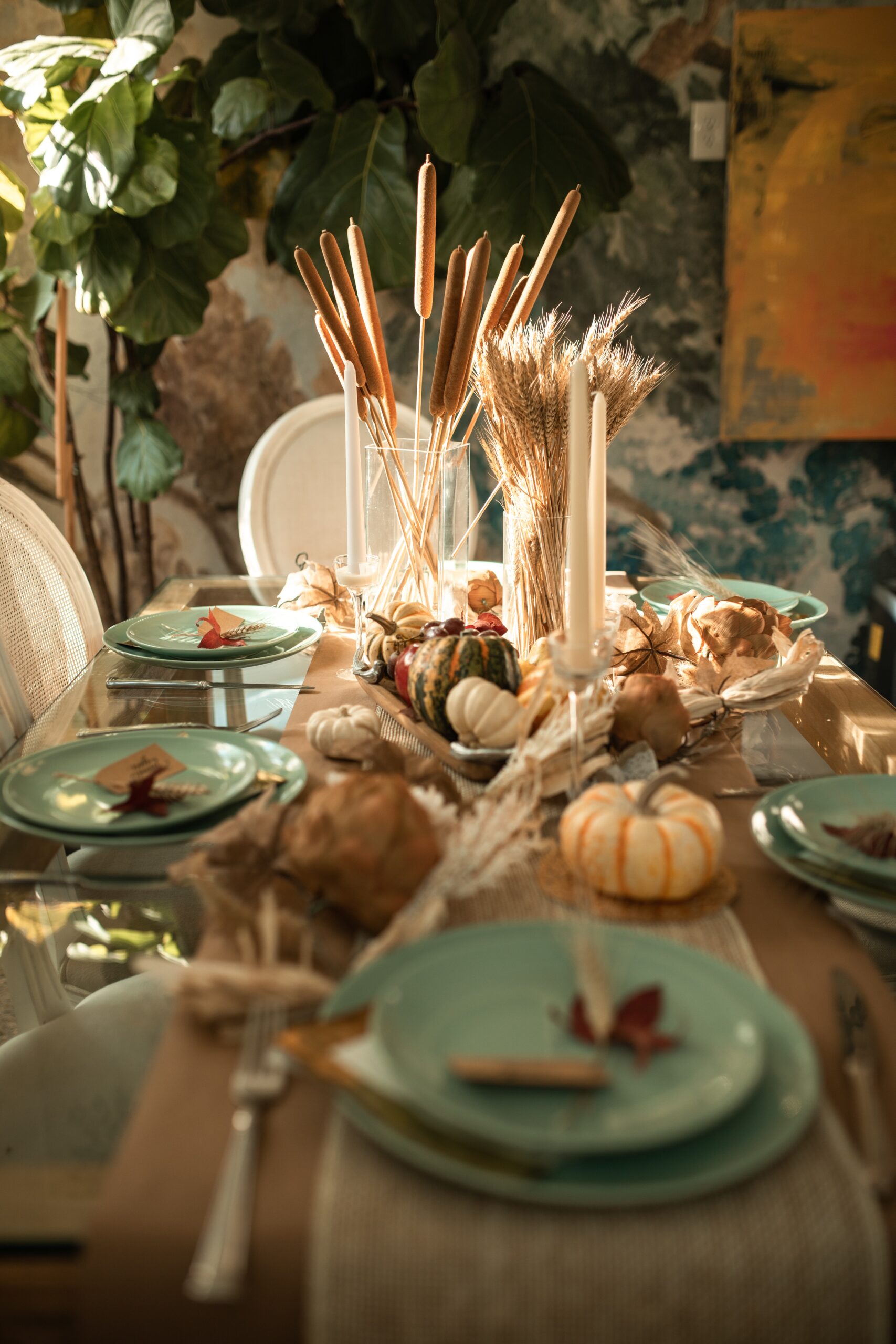 thanksgiving tablescape including dishware, pumpkins and plants