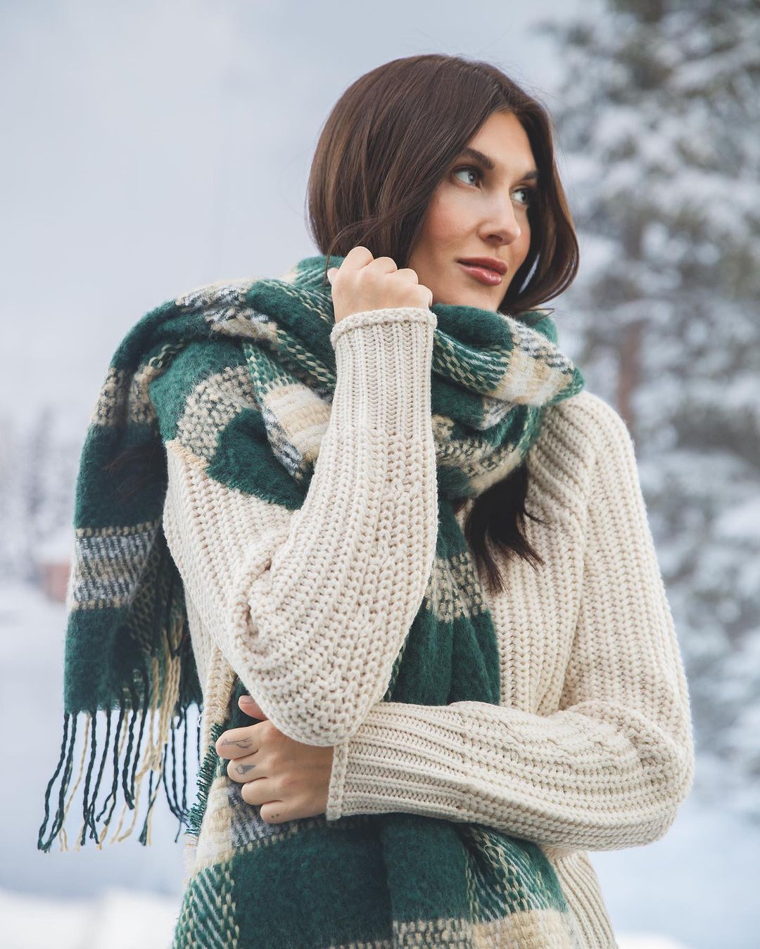 model wearing white sweater with green and white plaid scarf