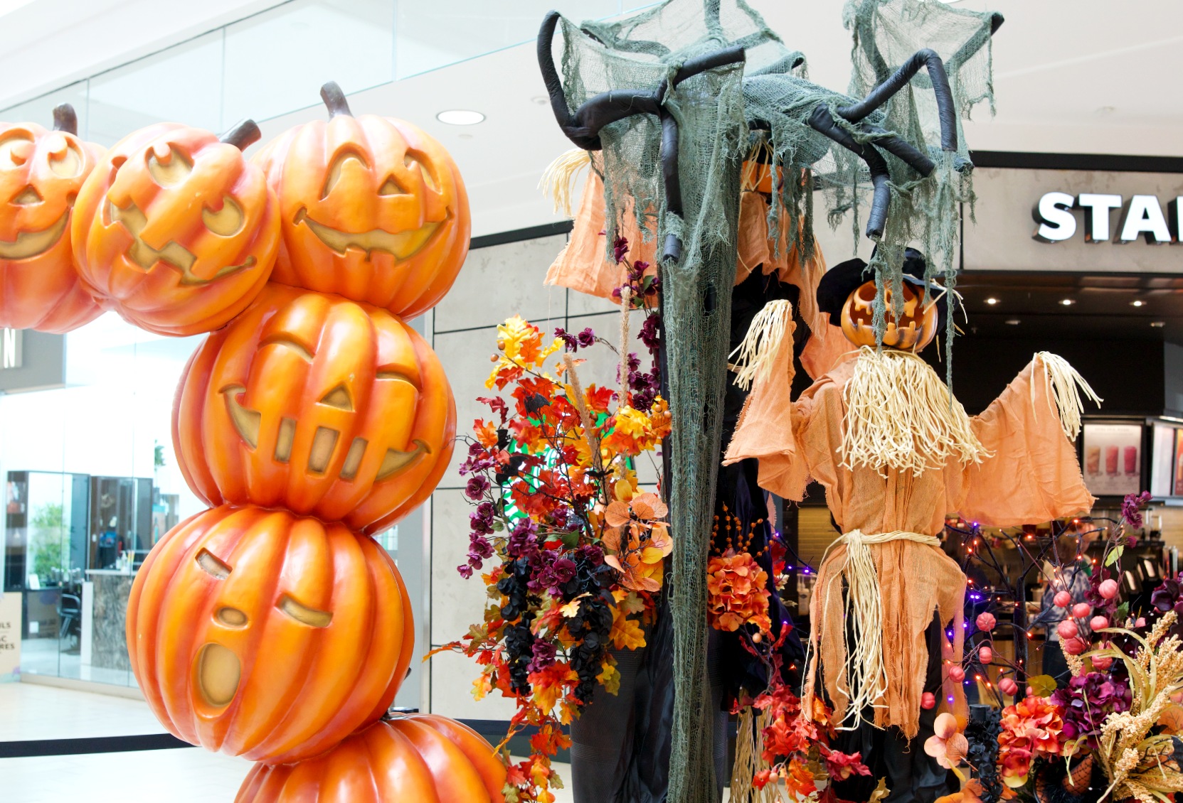 Halloween pumpkin arch with a pumpkin scarecrow as decor