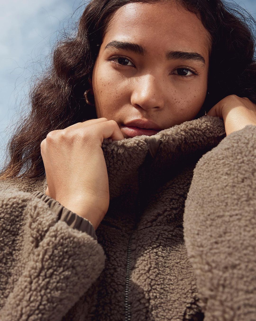 model wearing brown fleece turtleneck sweater