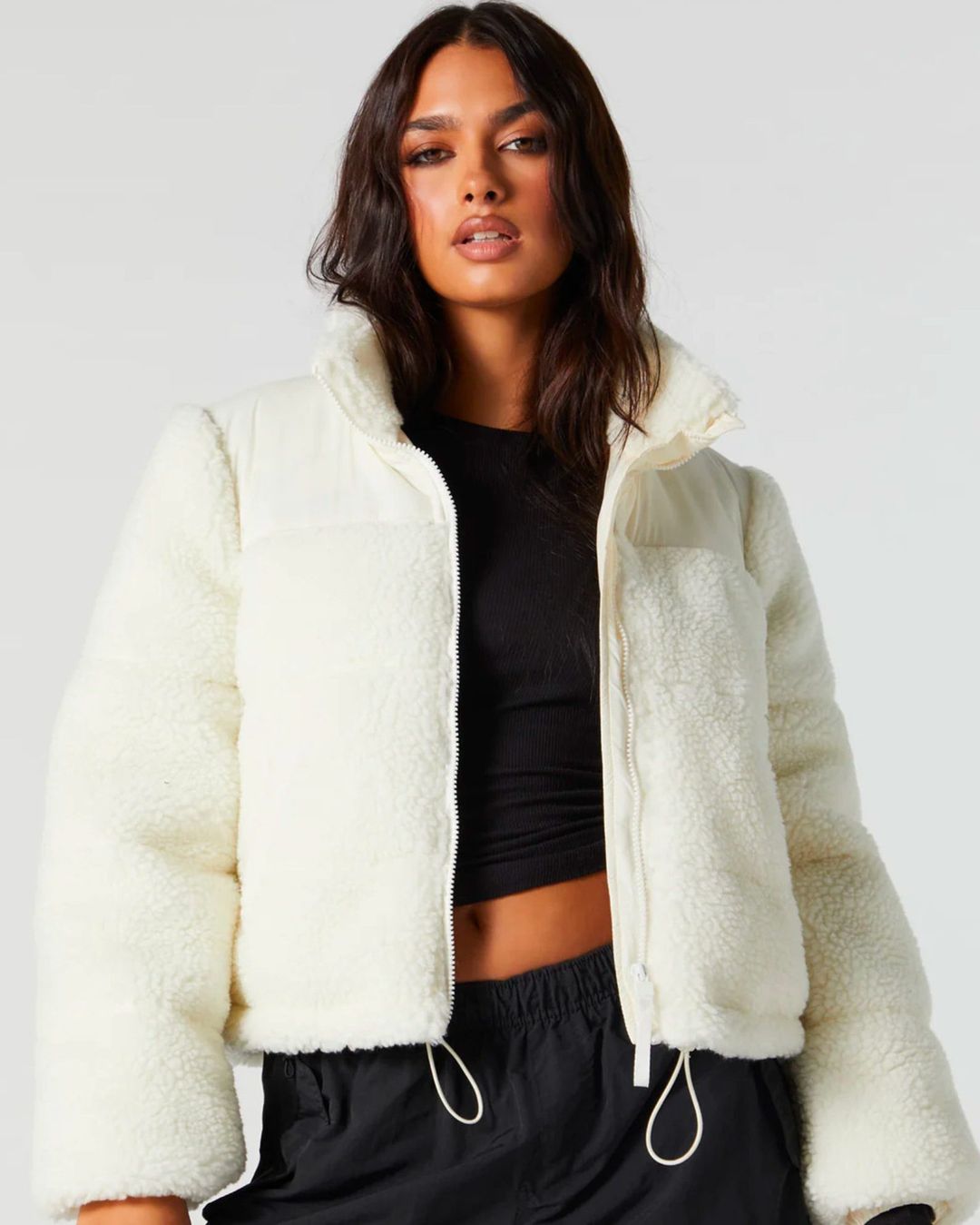 model wearing black crop top with white fuzzy jacket