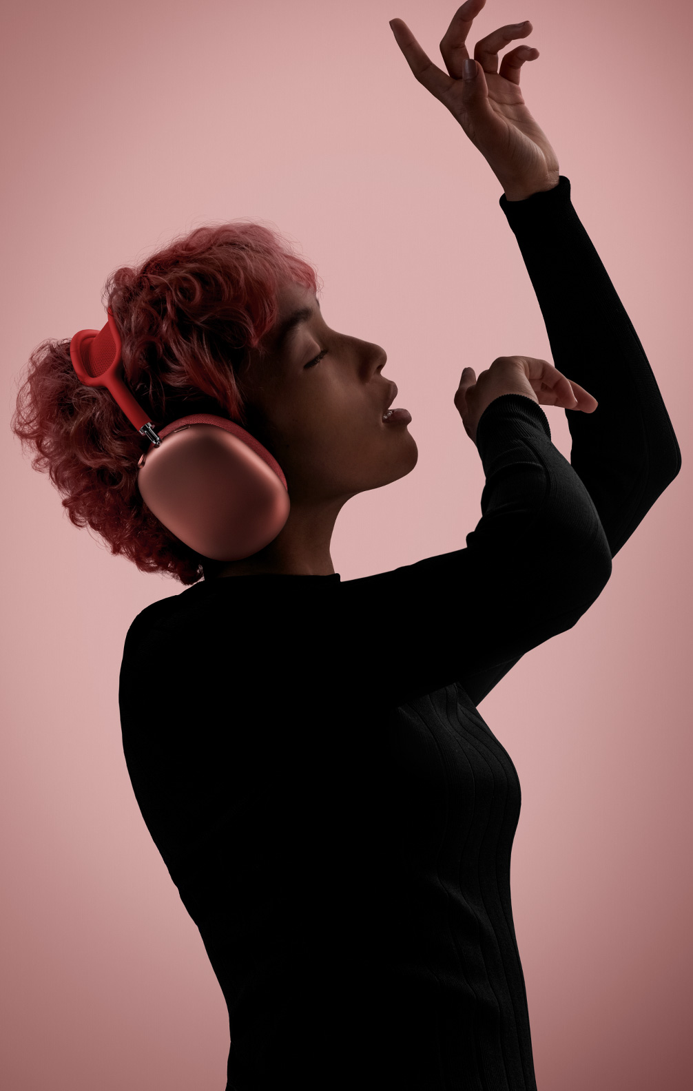 muted tone image of a woman wearing apple airpods max in red