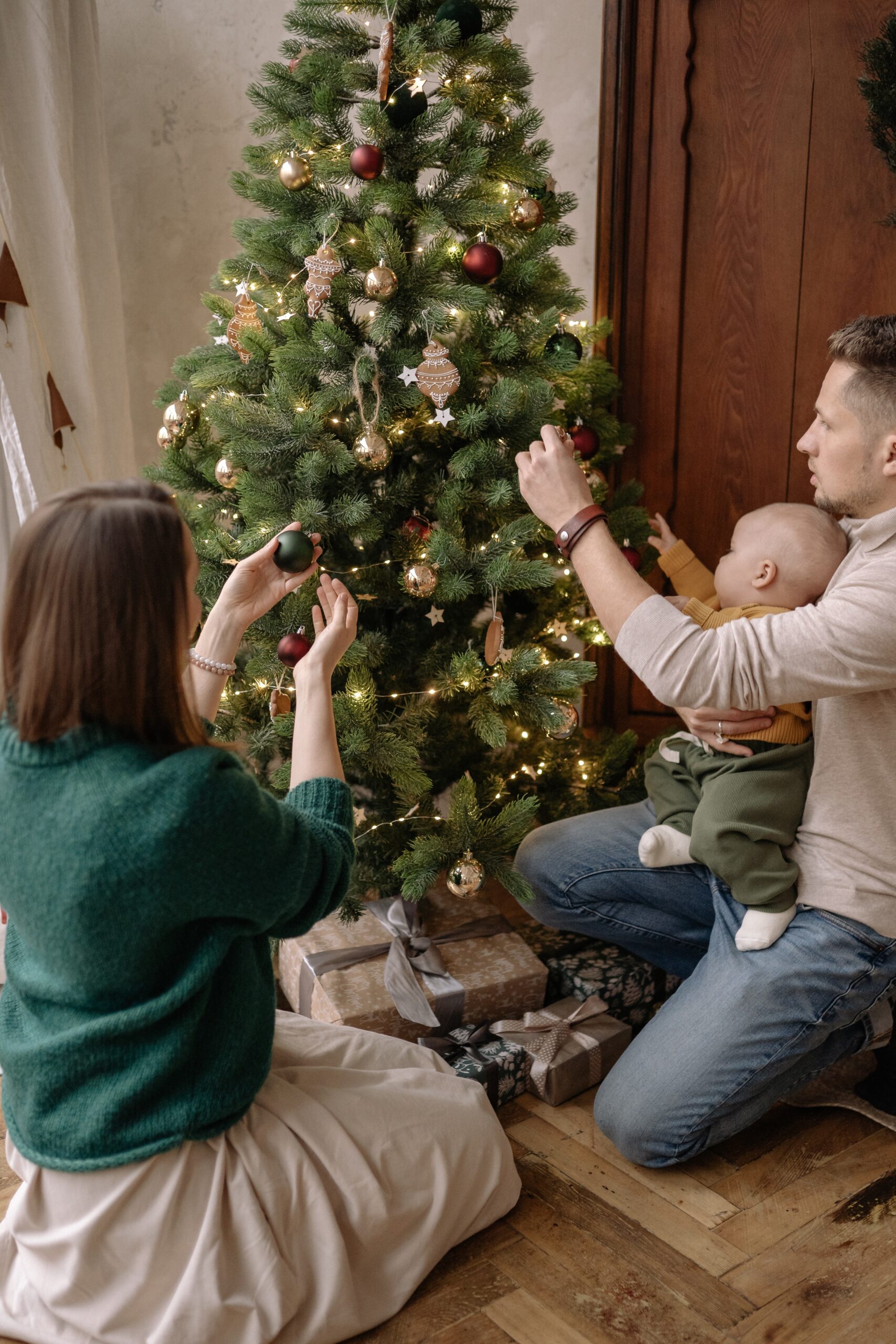 A family putting up ornaments on a Christmas tree
