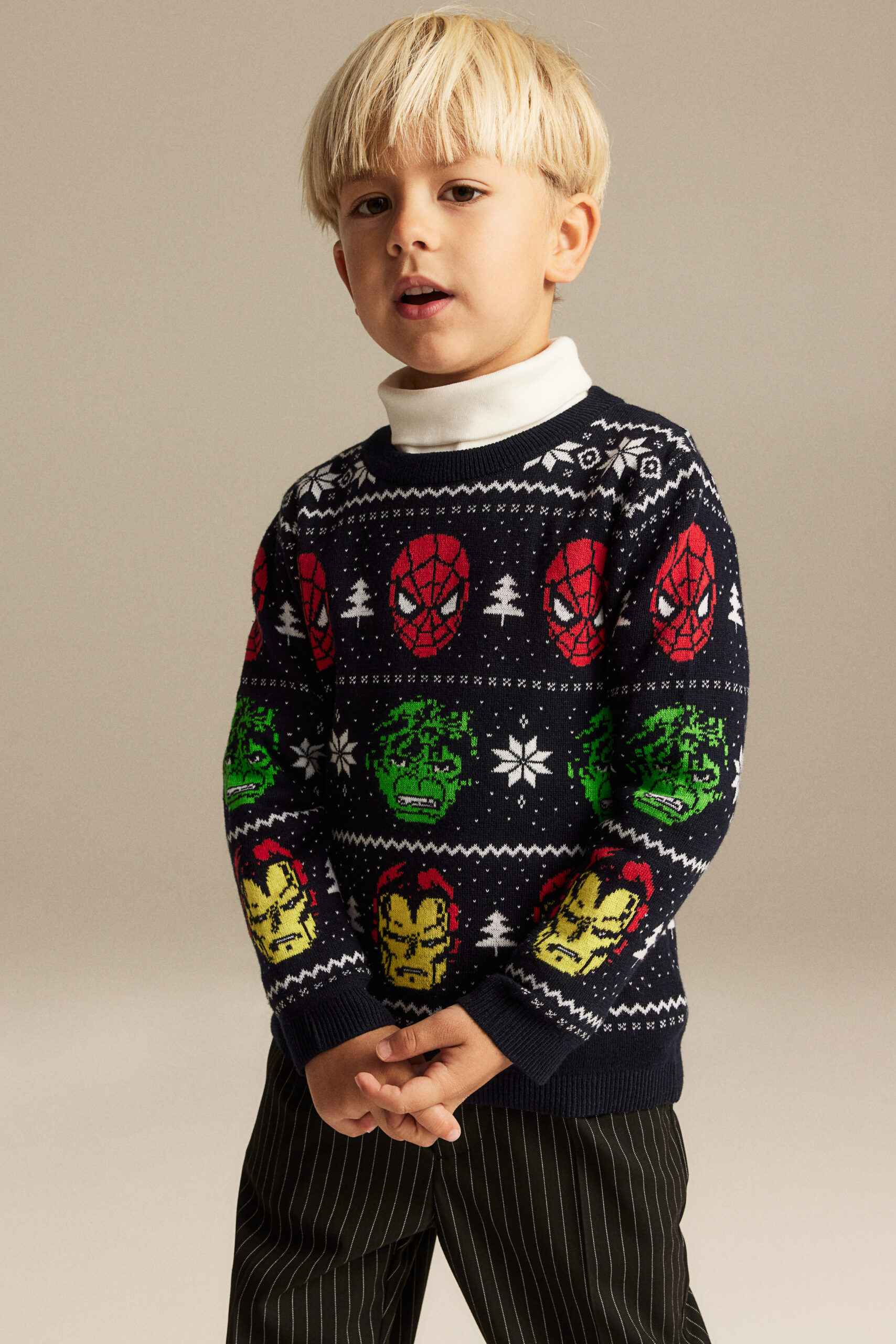 boy wearing jacquard-knit sweater with marvel characters including Spiderman, The Hulk and Iron Man