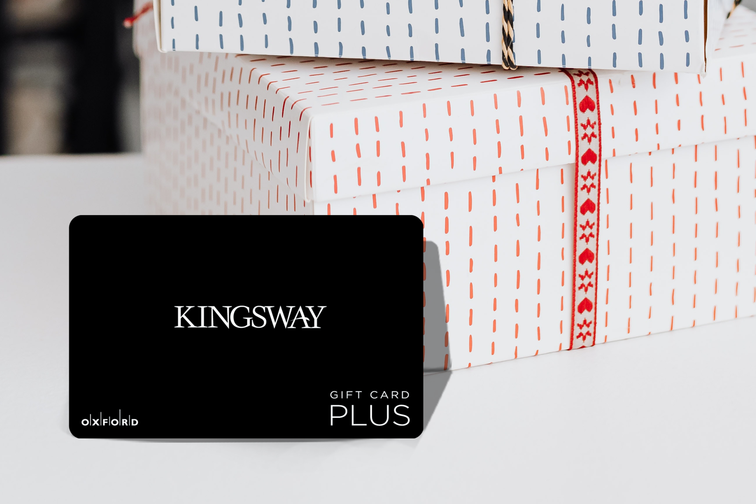 promotional image of a black kingsway gift card in front of two gift boxes