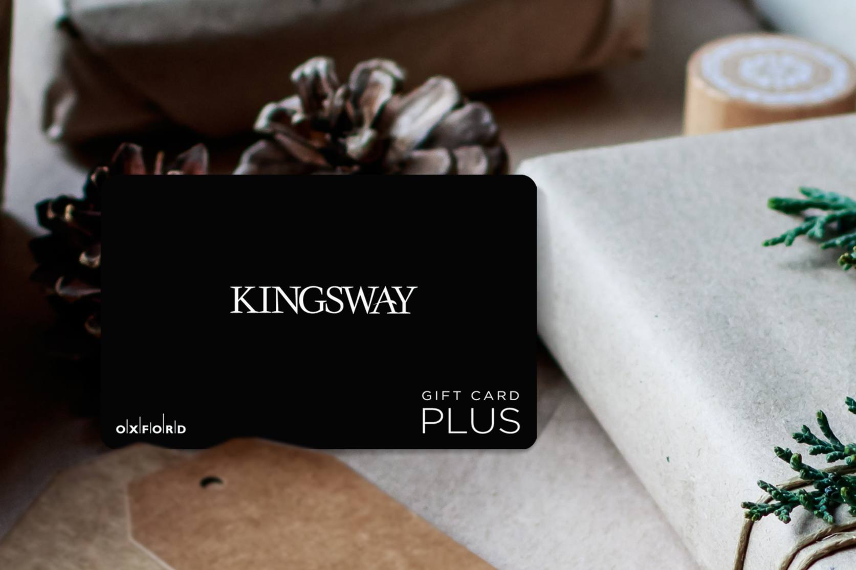 promotional image of a black Kingsway gift card surrounded by gift-wrapped books in a holiday setting