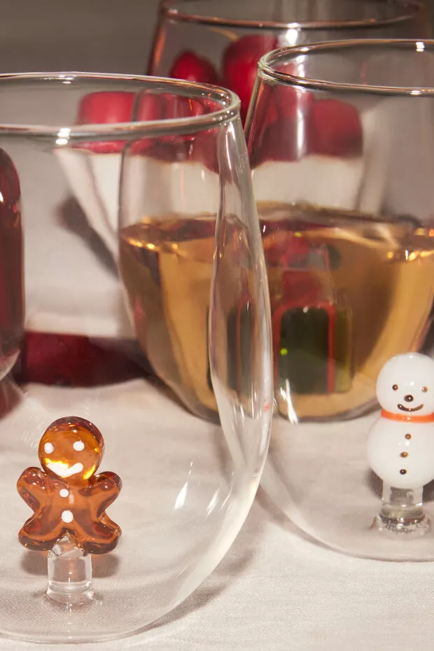 close-up photo of stemless wine glasses with gingerbread man and snowman inside