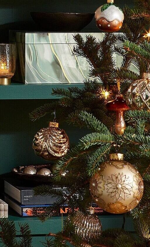 close up photo of Christmas tree decorated with ornaments and holiday decor on shelves