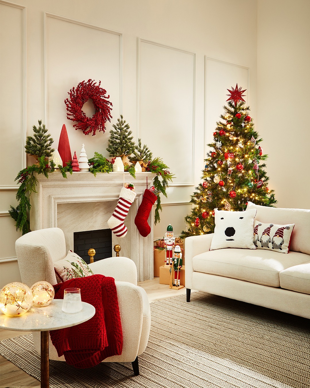 living room with holiday decor including a Christmas tree, pillows, throws, and stockings hanging on a mantle