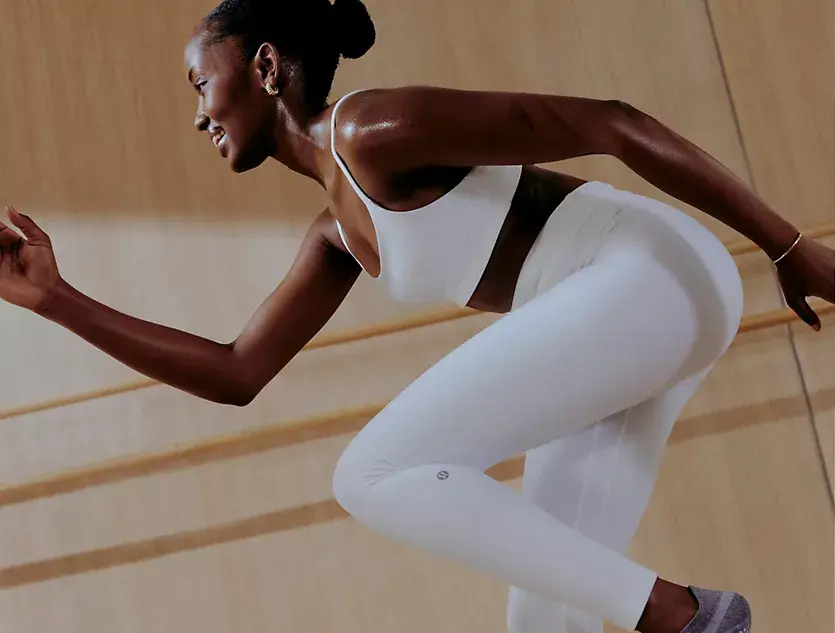 athlete wearing white lululemon sports bra and leggings while running