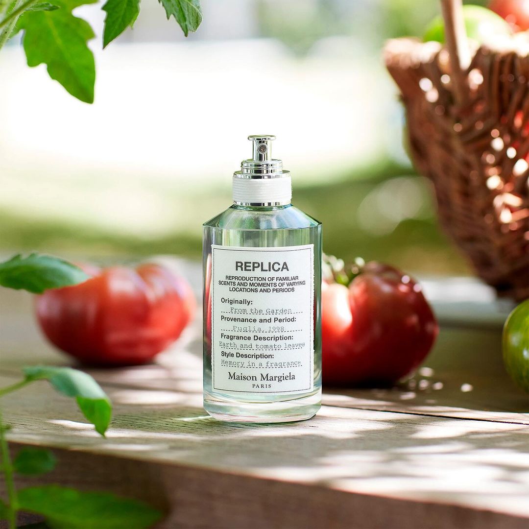 bottle of Replica perfume by Maison Margiela in a garden setting