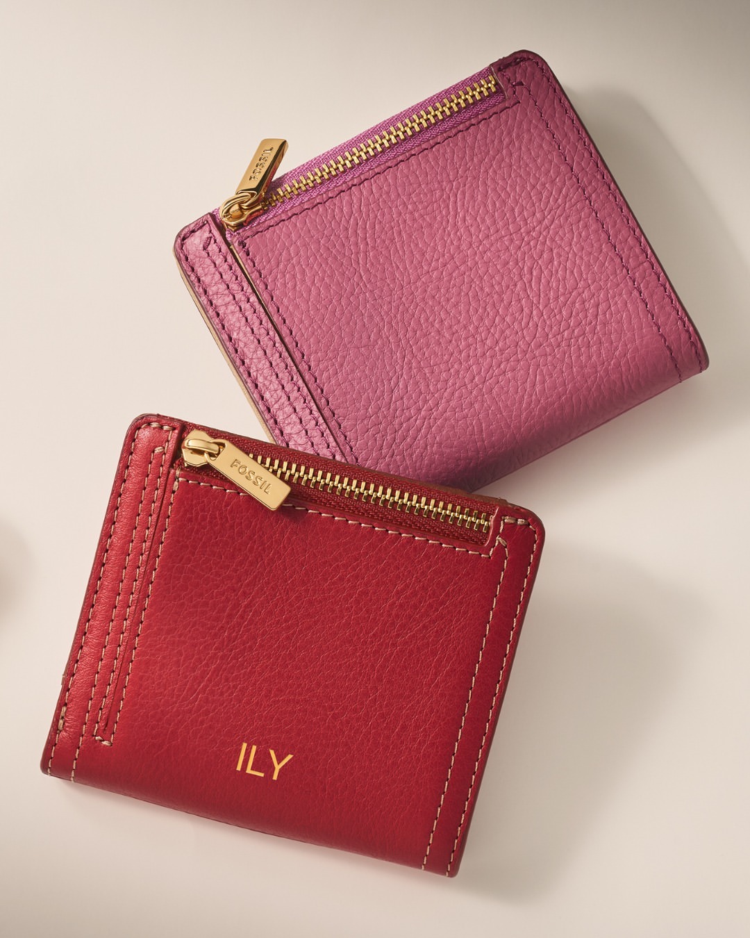 small pink wallet with gold zipper and small red wallet with gold zipper and embroidered "ILY"