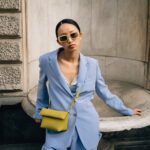 model wearing baby blue suit and yellow purse