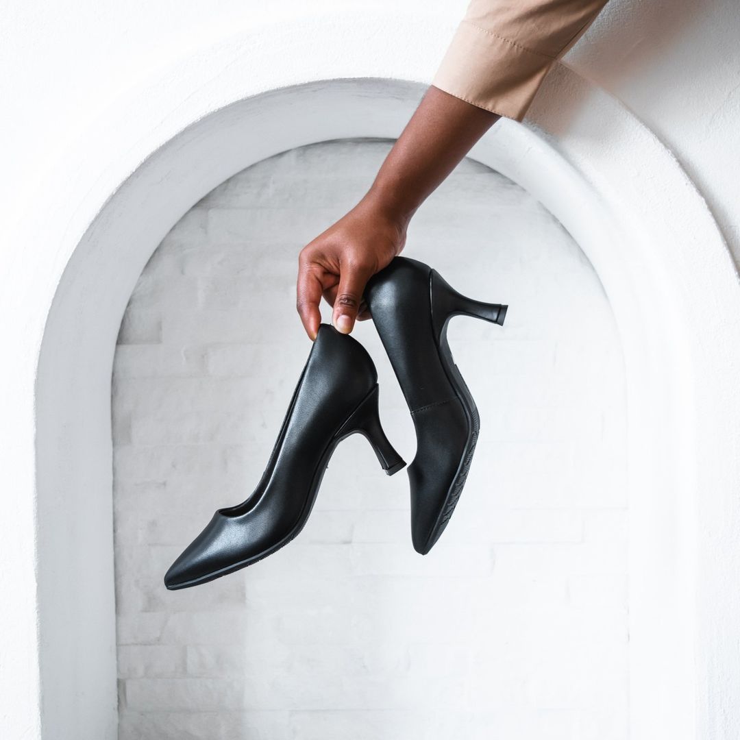 model holding a pair of black heels