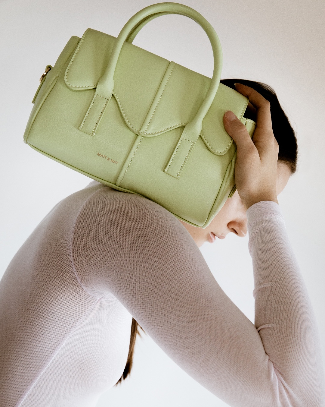 model holding light green purse from Matt & Nat