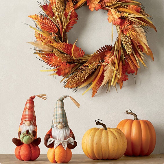 orange, yellow, and brown autumn wreath, decorative gnomes, and pumpkins