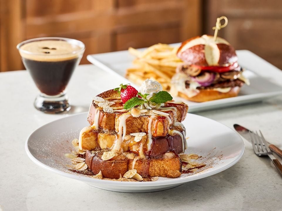 plate of french toast with espresso drink and burger and fries in background