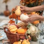 fall tablescape with basket of pumpkins and gourds