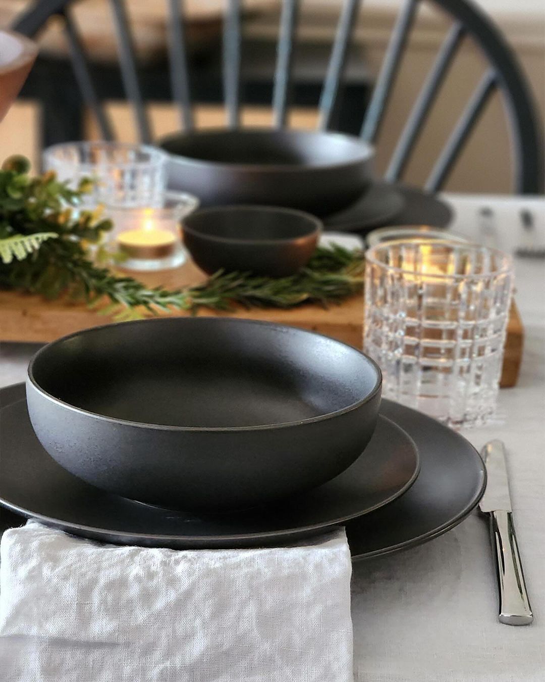 black dining set with bowls and plates with holiday table decor