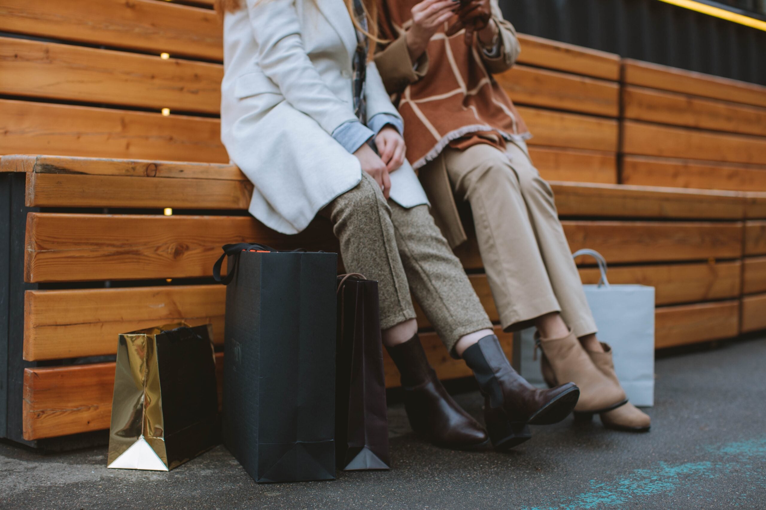 Two people sitting with multiple shopping bags