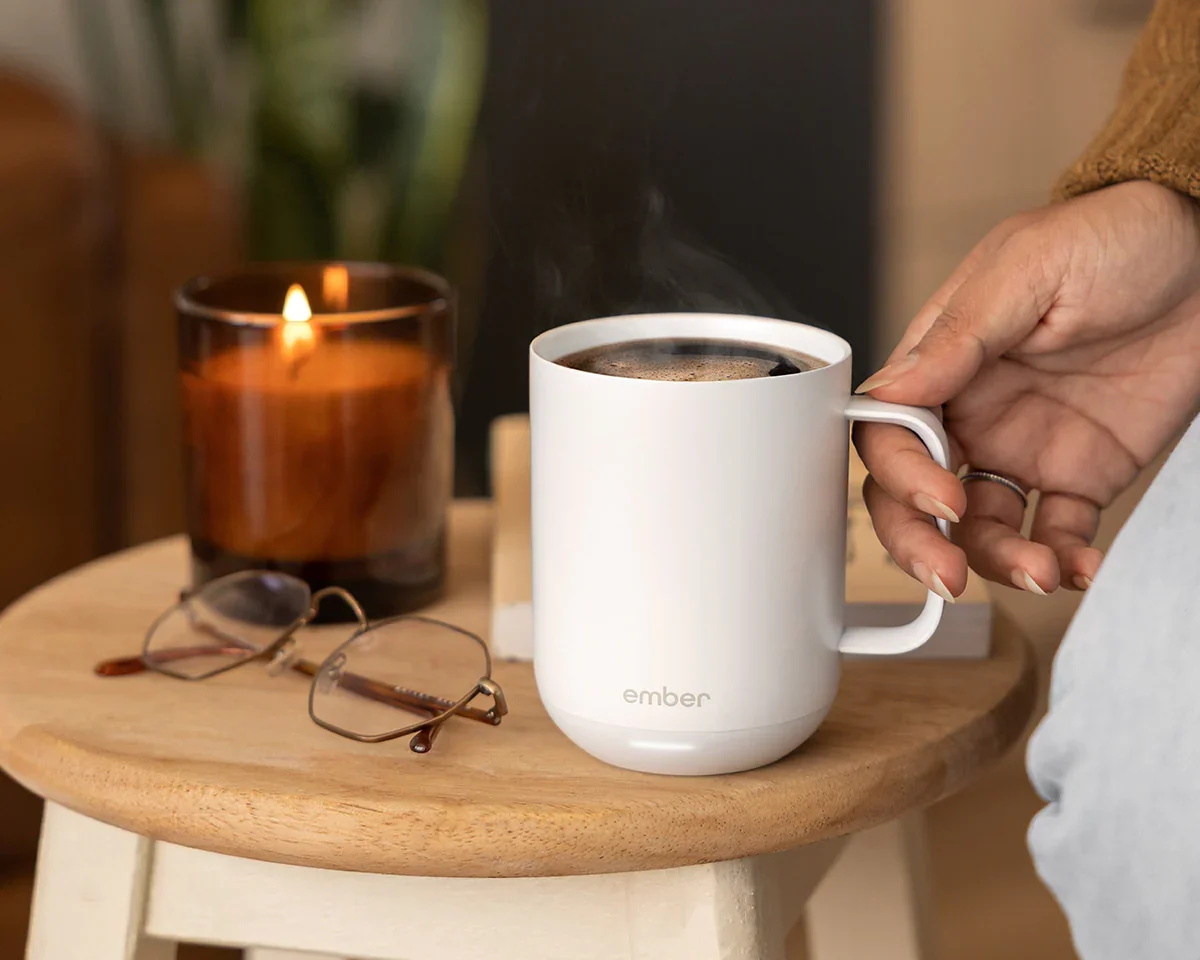 Mug on side table with glasses and a lit candle