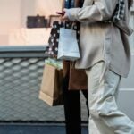 Woman and Man holding shopping bags outside of a store.