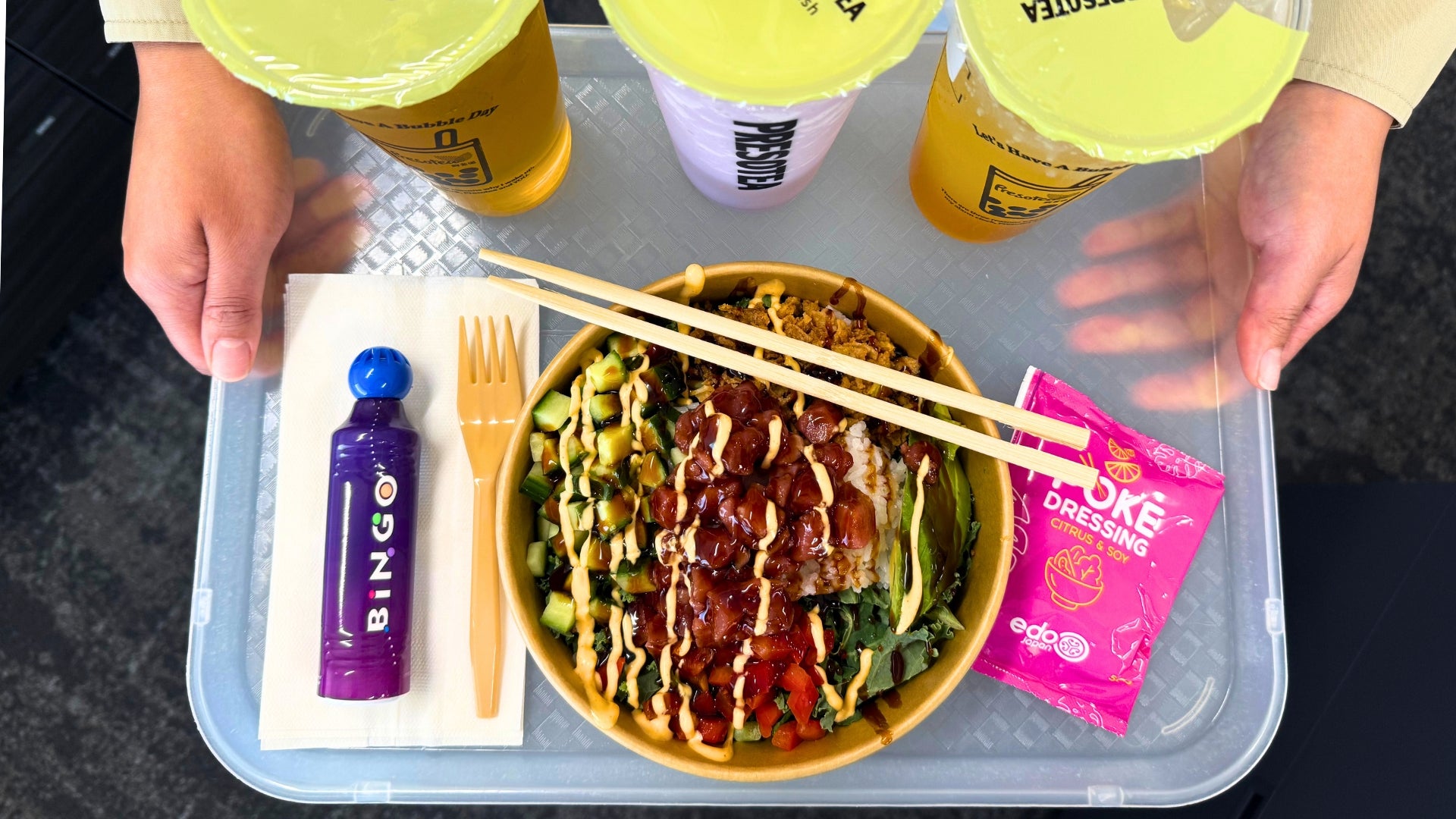 Food court tray holding a bowl of poke, bubble tea, and Bingo dabber