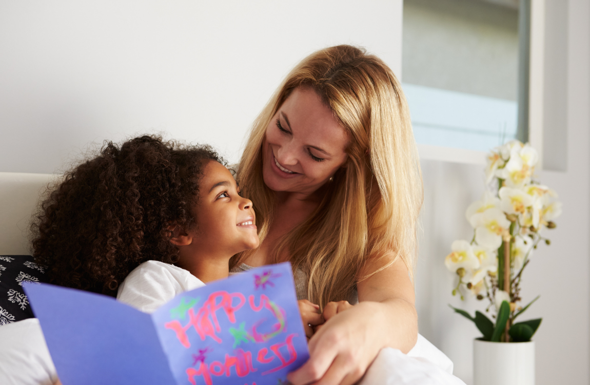 Mom & Daughter with card in bed