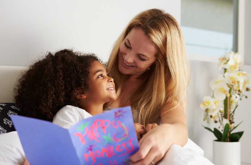 Mom & Daughter with card in bed